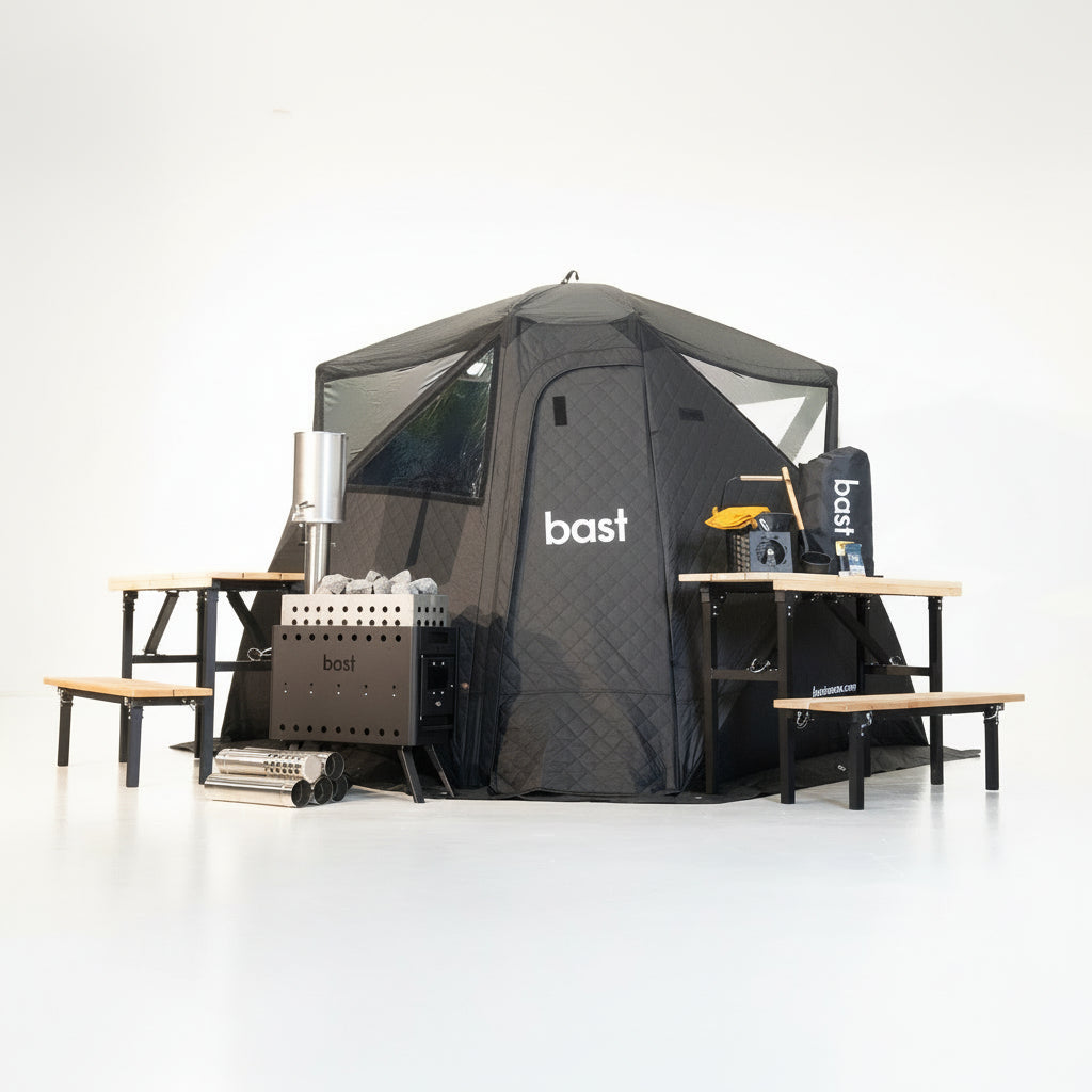 Black sauna tent with benches and sauna accessories on a white background, featuring the brand 'bast'.
