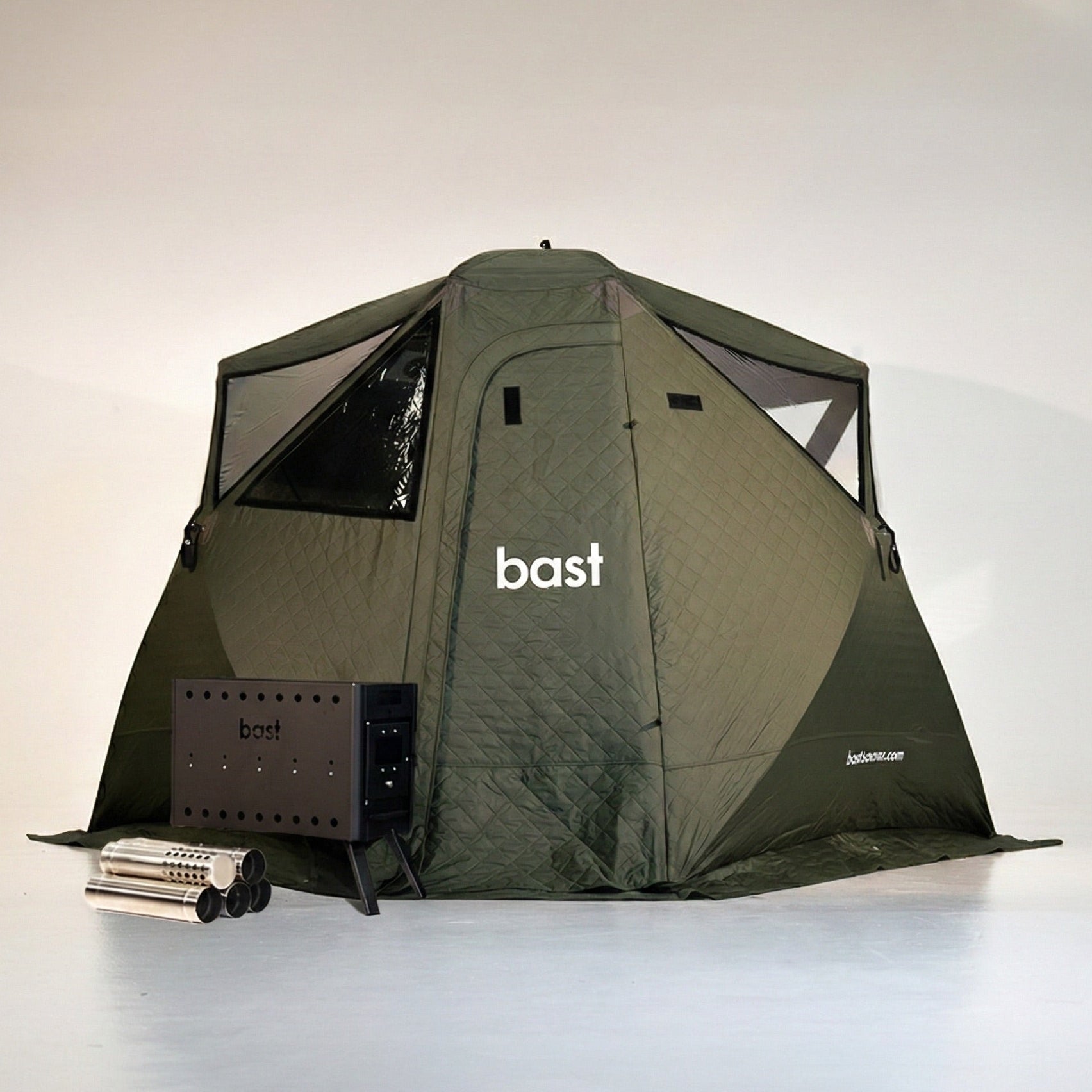 green outdoor sauna tent with 'bast' branding, surrounded by sauna equipment and accessories on a white background