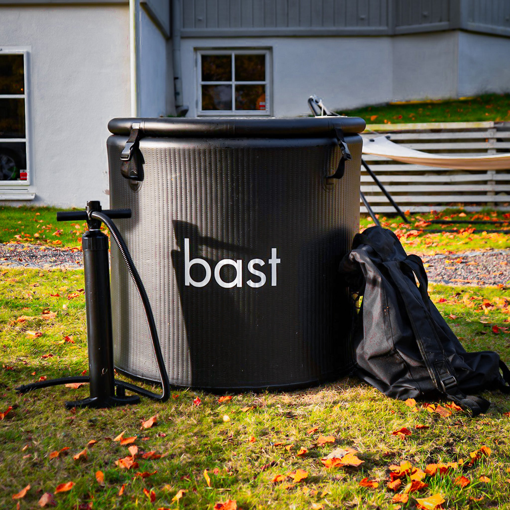 black inflatable ice bath tub and pump on grass