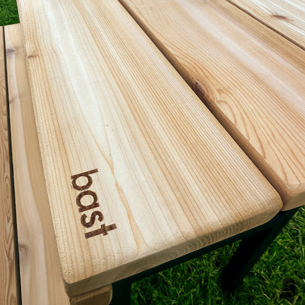 Wooden product with 'bast' branding on a grassy background