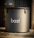 Inflatable ice bath tub with 'bast' branding on a wooden deck.