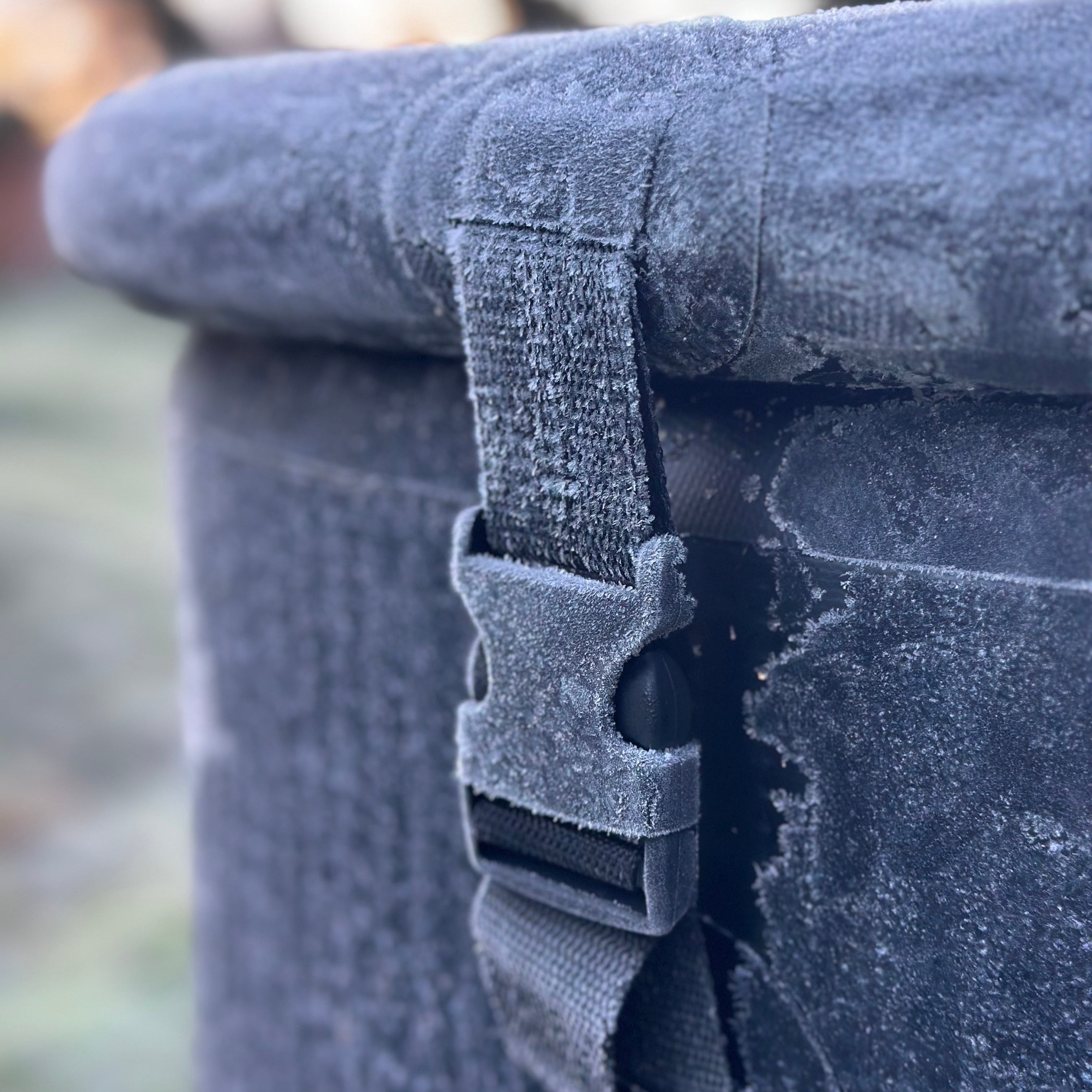 Frost-covered inflatable ice bath with a strap in a cold outdoor setting